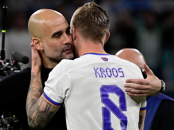 Manchester Citys Spanish coach Josep Guardiola (C) hugs Real Madrids German midfielder Toni Kroos (R) and Manchester Citys English midfielder Phil Foden at the end of the UEFA Champions League semi-final second leg football match between Real Madrid CF and Manchester City at the Santiago Bernabeu stadium in Madrid on May 4, 2022. (Photo by JAVIER SORIANO / AFP) (Photo by JAVIER SORIANO/AFP via Getty Images)
