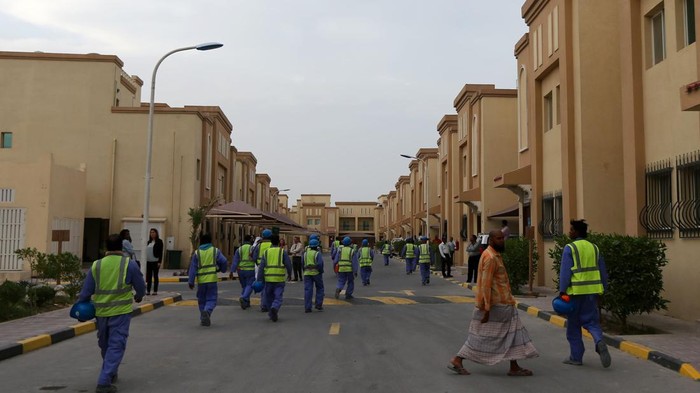 Foreign laborers working on the construction site of the al-Wakrah football stadium, one of the Qatars 2022 World Cup stadiums, sit in a bus as they come back to their accomodation at the Ezdan 40 compound after finishing work on May 4, 2015, in Dohas Al-Wakrah southern suburbs. The Qatari government has announced new projects to provide better accommodation for up to one million migrant workers. Today they organised a media tour of existing housing camps and new ones. AFP PHOTO / MARWAN NAAMANI (Photo by MARWAN NAAMANI / AFP)        (Photo credit should read MARWAN NAAMANI/AFP via Getty Images)