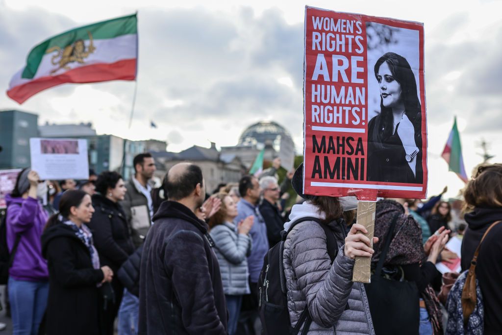 BERLIN, GERMANY - OCTOBER 15: Demonstrators, some hold banners with the image of Mahsa Amini and Shah-era flags, march in solidarity with protesters in Iran on October 15, 2022 in Berlin, Germany. Nationwide protests in Iran following the death of Mahsa Amini in mid-September are ongoing, with over 200 people killed in clashes with police so far. (Photo by Omer Messinger/Getty Images)