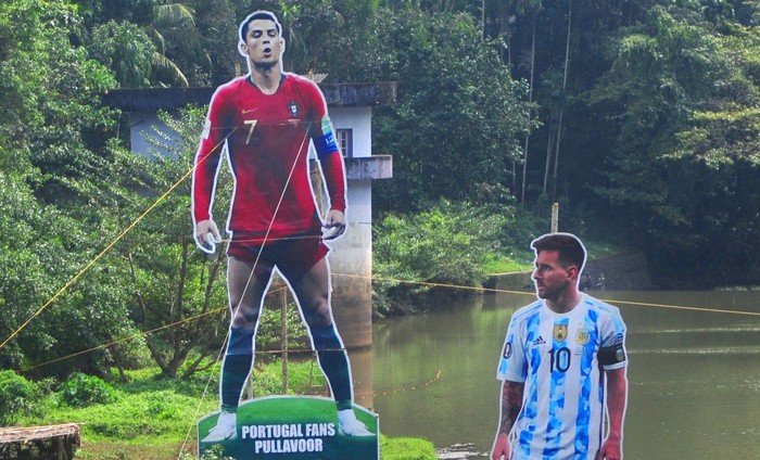 Neymar, Ronaldo, Messi Fans wave flags next to the giant cutouts of players from Brazil's Neymar (L), Portuguese Cristiano Ronaldo (C) and Argentine Lionel Messi, erected by football fans in river Cherupuzha at Kozhikode in India's Kerala state on November 7, 2022, ahead of the Qatar 2022 FIFA World Cup football tournament. (Photo by AFP) (Photo by -/AFP via Getty Images)