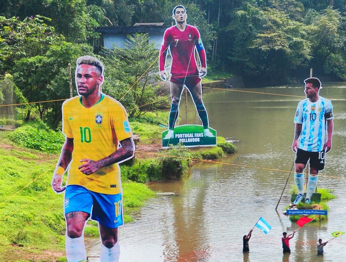 Neymar, Ronaldo, Messi Fans wave flags next to the giant cutouts of players from Brazil's Neymar (L), Portuguese Cristiano Ronaldo (C) and Argentine Lionel Messi, erected by football fans in river Cherupuzha at Kozhikode in India's Kerala state on November 7, 2022, ahead of the Qatar 2022 FIFA World Cup football tournament. (Photo by AFP) (Photo by -/AFP via Getty Images)