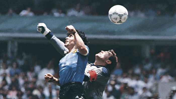 MEXICO CITY, MEXICO - JUNE 22: Diego Maradona of Argentina uses his hand to score the first goal of his team during a 1986 FIFA World Cup Quarter Final match between Argentina and England at Azteca Stadium on June 22, 1986 in Mexico City, Mexico. Maradona later claimed that the goal was scored by The Hand Of God. (Photo by Archivo El Grafico/Getty Images)