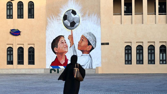 A woman walks past a mural in Doha on November 8, 2022, ahead of the Qatar 2022 FIFA World Cup football tournament. (Photo by Gabriel BOUYS / AFP) (Photo by GABRIEL BOUYS/AFP via Getty Images)