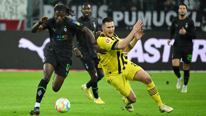 Moenchengladbachs French midfielder Kouadio Kone (L) and Dortmunds German defender Niklas Suele vie for the ball during the German first division Bundesliga football match between Borussia Moenchengladbach v Borussia Dortmund in Moenchengladbach, western Germany, on November 11, 2022. (Photo by INA FASSBENDER / AFP) / DFL REGULATIONS PROHIBIT ANY USE OF PHOTOGRAPHS AS IMAGE SEQUENCES AND/OR QUASI-VIDEO