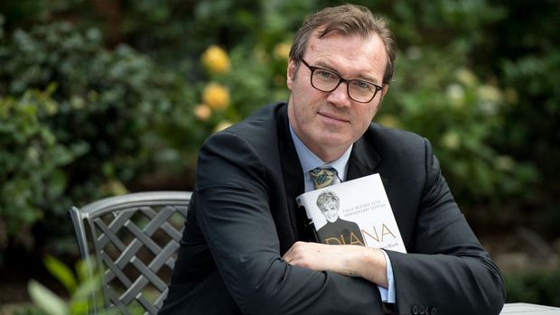 Author Andrew Morton poses with a copy of his book, 