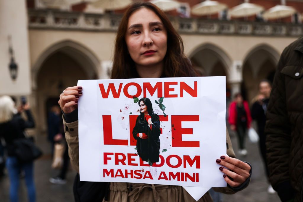 A woman holds a banner during solidarity demonstration in memory of Mahsa Amini, at the Main Square in Krakow, Poland on October 1st, 2022. Protests have erupted across Iran and worldwide after Mahsa Amini, a 22-year old Kurdish Iranian girl was brutally killed by the morality police of Islamic republic for her alleged failure to fully observe Islamic dress regulations. (Photo by Beata Zawrzel/NurPhoto via Getty Images)