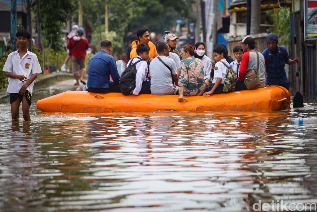 Banjir yang merendam perumahan di Periuk, Tangerang, membuat akses jalan terputus. Perahu rescue pun dikerahkan untuk mengangkut warga.