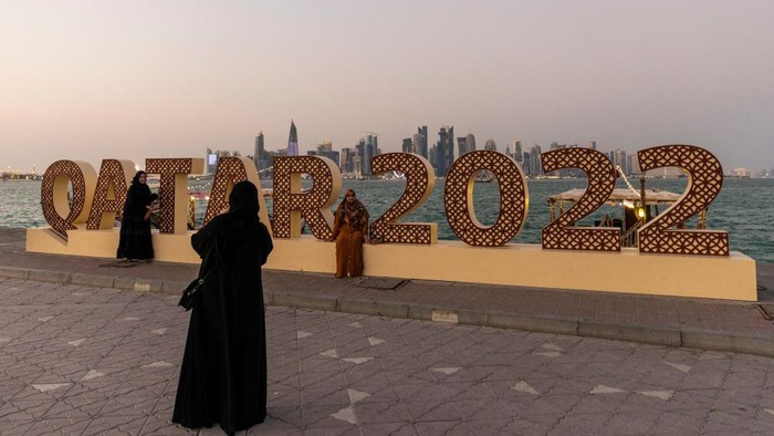 DOHA, QATAR - NOVEMBER 14: Members of the public pose for a pictures next to a Qatar 2022 logo at Doha Corniche ahead of the FIFA World Cup Qatar 2022 on November 14, 2022 in Doha, Qatar. (Photo by Maja Hitij - FIFA/FIFA via Getty Images)