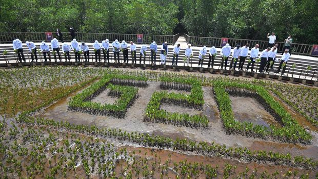 Presiden Joko Widodo (kedua belas kanan) bersama para kepala negara/kepala pemerintahan negara anggota G20 dan pimpinan organisasi internasional mengangkat pacul usai menanam mangrove saat rangkaian KTT G20 Indonesia di Taman Hutan Raya, Ngurah Rai, Denpasar, Bali, Selasa (16/11/2022). ANTARA FOTO/Media Center G20 Indonesia/Sigid Kurniawan/wsj.