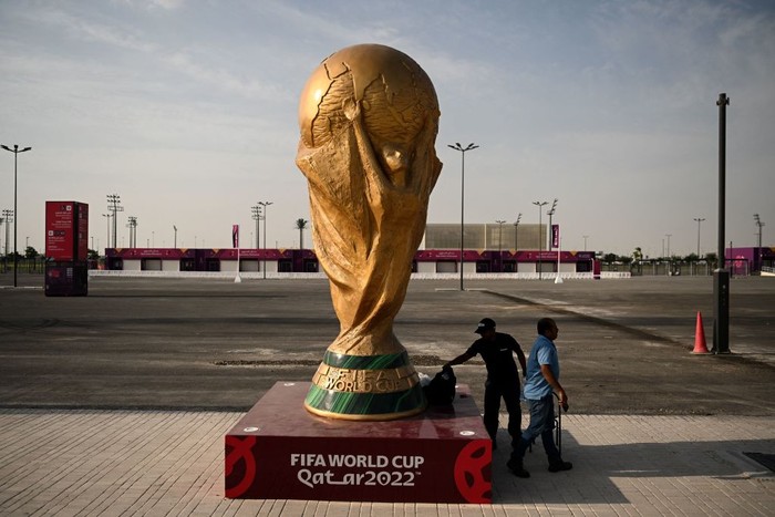 Stadion Ahmed bin Ali, Piala Dunia 2022 Men walk past a FIFA World Cup trophy replica outside the Ahmed bin Ali Stadium in Al-Rayyan on November 12, 2022, ahead of the Qatar 2022 FIFA World Cup football tournament. (Photo by Kirill KUDRYAVTSEV / AFP) (Photo by KIRILL KUDRYAVTSEV/AFP via Getty Images)