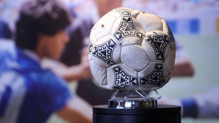 Graham Budd poses with the match ball used in the 1986 FIFA World Cup Quarter-Final football match between Argentina and England, played at the Estadio Azteca, Mexico City, during a photocall ahead of its auction, at Wembley Stadium in London on November 1, 2022. - The ball that Diego Maradona used to score his infamous 