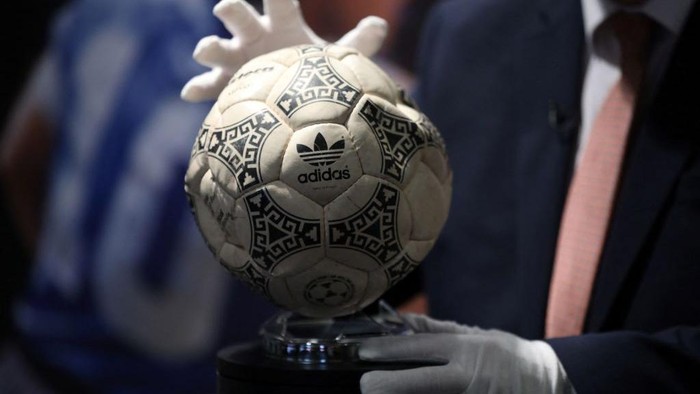 Graham Budd poses with the match ball used in the 1986 FIFA World Cup Quarter-Final football match between Argentina and England, played at the Estadio Azteca, Mexico City, during a photocall ahead of its auction, at Wembley Stadium in London on November 1, 2022. - The ball that Diego Maradona used to score his infamous 