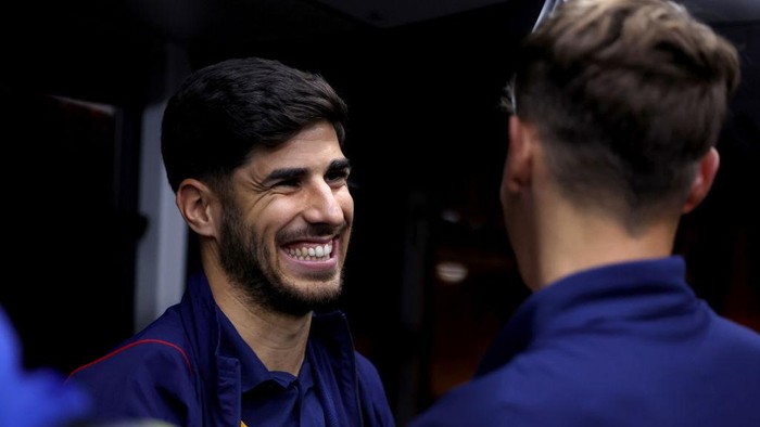 DOHA, QATAR - NOVEMBER 18: Marco Asensio smiles after boarding the airport bus after the arrival of Team Spain ahead of FIFA World Cup Qatar 2022 at Hamad International Airport on November 18, 2022 in Doha, Qatar. (Photo by Mohamed Farag - FIFA/FIFA via Getty Images)