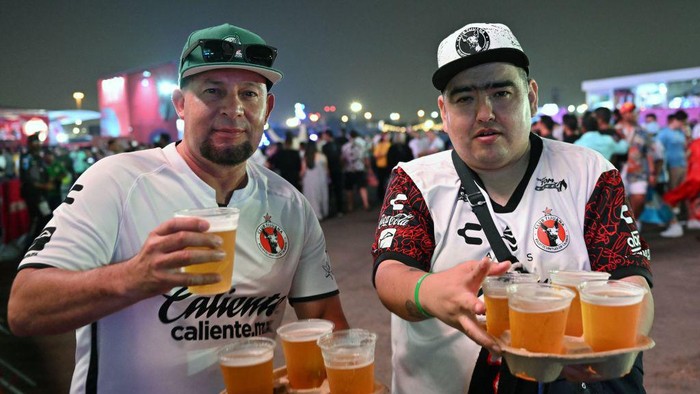 Men enjoy a beer during the FIFA Fan Festival opening day at Al Bidda park in Doha on November 19, 2022, ahead of the Qatar 2022 World Cup football tournament. (Photo by Glyn KIRK / AFP) (Photo by GLYN KIRK/AFP via Getty Images)