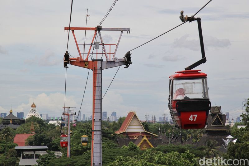 Pengunjung TMII melihat pemandangan atas dari dalam wahana kereta gantung di TMII, Jakarta Timur, Minggu (20/11/2022).