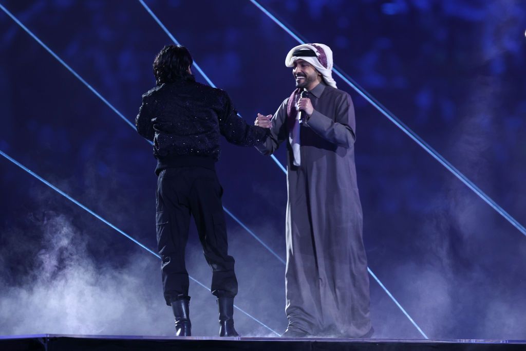 AL KHOR, QATAR - NOVEMBER 20: South Korean pop star Jung Kook of BTS greets Qatari singer Fahad Al-Kubaisi on stage during the opening ceremony of the FIFA World Cup Qatar 2022 Group A match between Qatar and Ecuador at Al Bayt Stadium on November 20, 2022 in Al Khor, Qatar. (Photo by James Williamson - AMA/Getty Images)