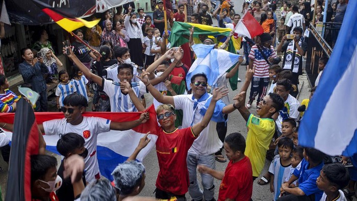 Soccer fans wave the flags of participating countries during a parade ahead of the kick-off of the Qatar FIFA World Cup, in Pambusuang village, West Sulawesi, Indonesia, Sunday, Nov. 20, 2022. Qatar prepared Sunday to open the Middle East's first FIFA World Cup before global leaders and soccer fans now pouring into this energy-rich nation after being battered by a regional boycott and international criticism. (AP Photo/Yusuf Wahil)