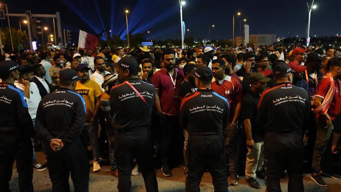 Policemen stand in line to limit the number of fans entering the fan zone to watch the World Cup, group A soccer match between Qatar and Ecuador in Doha, Sunday, Nov. 20, 2022. (AP Photo/Petr David Josek)