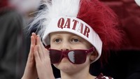 Penggemar sepakbola anak kecil menggunakan aksesori untuk memeriahkan Piala Dunia FIFA Qatar 2022. (Richard Sellers/Getty Images)