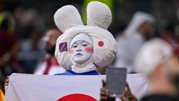 Salah satu suporter dari Jepang yang memakai kostum sangat unik sambil mengibarkan bendera Jepang. (Harry Langer/Getty Images)