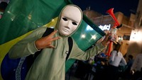 Seorang suporter Brasil mengenakan topeng berpose di Soud di Souq Waqif di Doha saat pertandingan pembukaan turnamen sepakbola Piala Dunia Qatar 2022, Minggu (20/11/2022). (Andrej Isakovic/Getty Images)