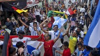 Kemeriahan tersebut berlangsung di sekitar jalanan rumah warga. Mereka memeriahkan hari pertama Piala Dunia FIFA yang digelar di Qatar.