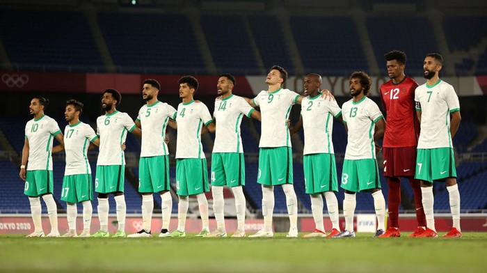 YOKOHAMA, JAPAN - JULY 25: Players of Team Saudi Arabia stand for the national anthem prior to the Mens First Round Group D match between Saudi Arabia and Germany on day two of the Tokyo 2020 Olympic Games at International Stadium Yokohama on July 25, 2021 in Yokohama, Kanagawa, Japan. (Photo by Francois Nel/Getty Images)