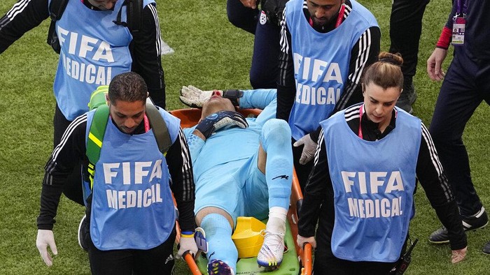 Medics carry Iran's goalkeeper Alireza Beiranvand from the pitch after sustaining an injury during the World Cup group B soccer match between England and Iran at the Khalifa International Stadium in Doha, Qatar, Monday, Nov. 21, 2022. (AP Photo/Pavel Golovkin)