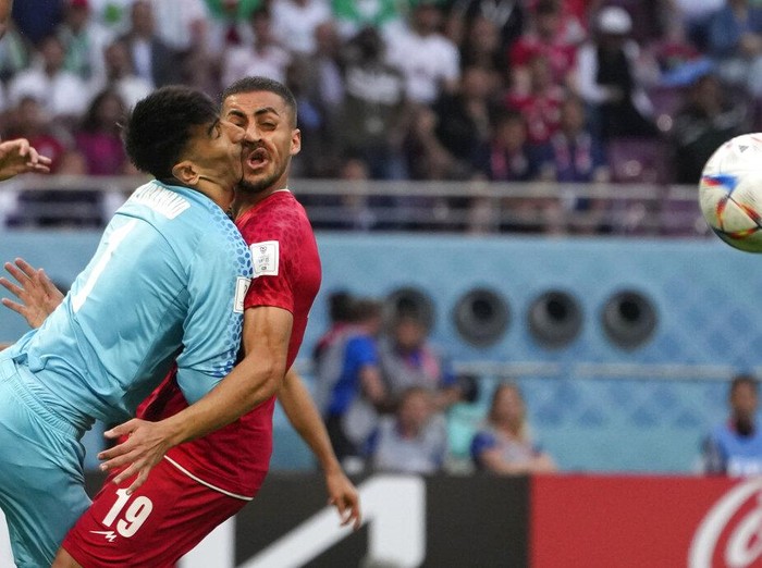 Iran's goalkeeper Alireza Beiranvand collides with Iran's Majid Hosseini, right, during the World Cup group B soccer match between England and Iran at the Khalifa International Stadium in Doha, Qatar, Monday, Nov. 21, 2022. (AP Photo/Alessandra Tarantino)