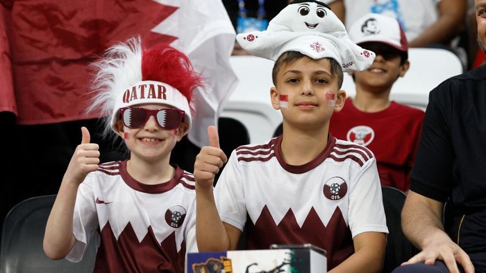 Dua supporter Qatar yang berpose saat difoto di tribun saat menyaksikan pertandingan Grup A Piala Dunia FIFA Qatar 2022 antara Qatar dan Ekuador di Stadion Al Bayt, Al Khor, Qatar, Minggu (20/11/2022).