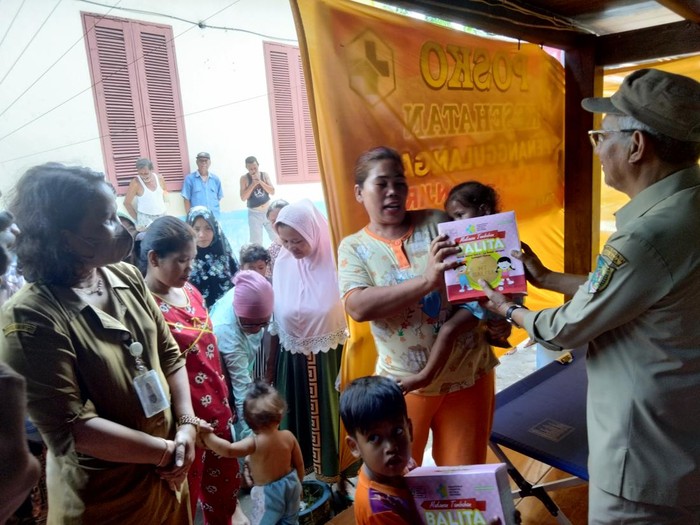 Kadis Kesehatan memberikan makanan tambahan ke balita di Pos Kesehatan posko pengungsian. Foto: Perdana Ramadhan/detikSumut