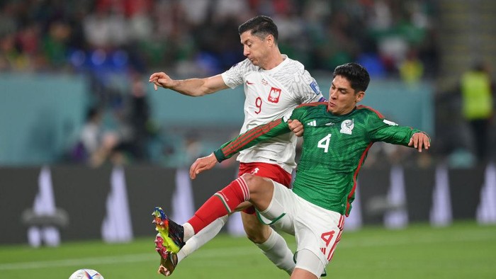 DOHA, QATAR - NOVEMBER 22: Robert Lewandowski of Poland battles for possession with Edson Alvarez of Mexico during the FIFA World Cup Qatar 2022 Group C match between Mexico and Poland at Stadium 974 on November 22, 2022 in Doha, Qatar. (Photo by Stuart Franklin/Getty Images)