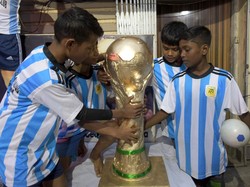 Anggota Fan Club Argentina menyentuh replika trofi Piala Dunia FIFA sehari sebelum pertandingan pertama Argentina di Piala Dunia Qatar 2022.  