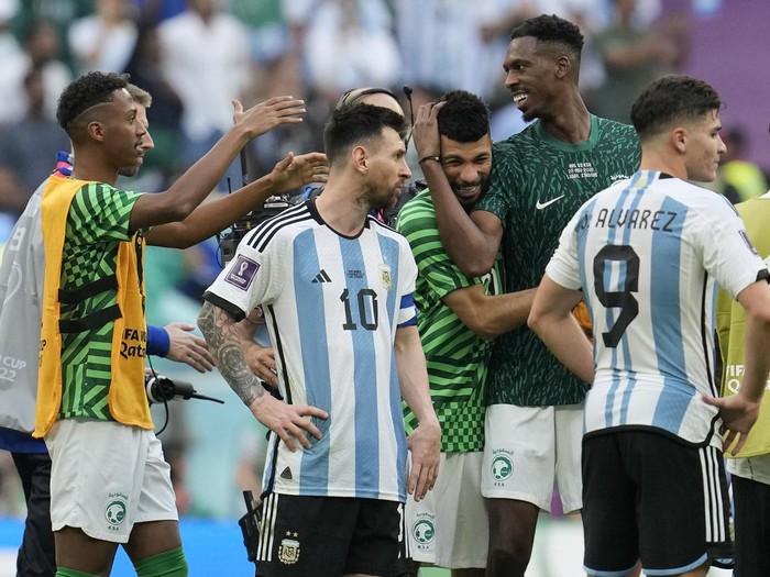 Argentina's Lionel Messi standing beside Saudi Arabia's players celebrating after winning the World Cup group C soccer match between Argentina and Saudi Arabia at the Lusail Stadium in Lusail, Qatar, Tuesday, Nov. 22, 2022. (AP Photo/Natacha Pisarenko)