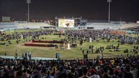 Pekerja migran menonton pertandingan Qatar vs Ekuador di Doha, Qatar, Minggu (20/11/2022). Layar raksasa dipasang di zona penggemar khusus di dekat kawasan industri itu.