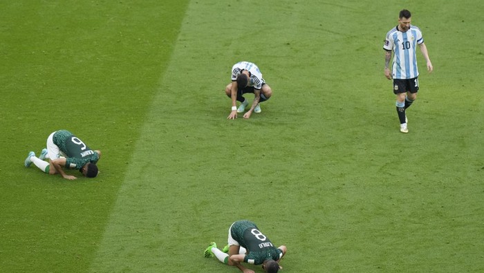Argentina's Lionel Messi, right, leaves the pitch as Saudi Arabia's Mohammed Al-Burayk, left, and teammate Abdulelha Al-Malki celebrate after their win in the World Cup group C soccer match between Argentina and Saudi Arabia at the Lusail Stadium in Lusail, Qatar, Tuesday, Nov. 22, 2022. (AP Photo/Luca Bruno)