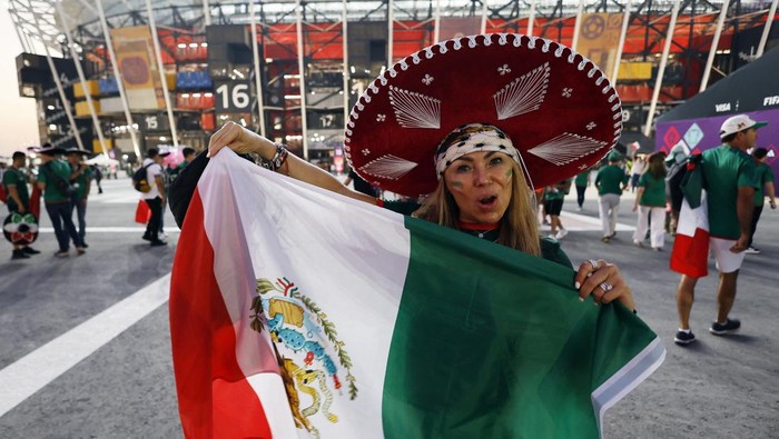 Bertopi Sombrero, Begini Gaya Suporter Cantik Meksiko Soccer Football - FIFA World Cup Qatar 2022 - Group C - Mexico v Poland - Stadium 974, Doha, Qatar - November 22, 2022 A Mexico fan displays a flag outside the stadium before the match REUTERS/Hamad I Mohammed