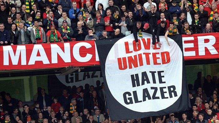 Manchester United supporters hold anti-Glazer family banners during their English Premier League football match against Liverpool at Old Trafford in Manchester, north-west England, on March 21,2010. AFP PHOTO/PAUL ELLIS -  FOR EDITORIAL USE ONLY Additional licence required for any commercial/promotional use or use on TV or internet (except identical online version of newspaper) of Premier League/Football League photos. Tel DataCo +44 207 2981656. Do not alter/modify photo. (Photo credit should read PAUL ELLIS/AFP via Getty Images)