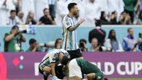 Terlihat Angel Di Maria terduduk lesu dan Messi berjalan melalui pemain Arab Saudi yang sujud syukur. (Foto: AP/Natacha Pisarenko)