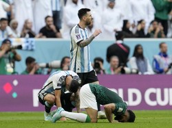 Terlihat Angel Di Maria terduduk lesu dan Messi berjalan melalui pemain Arab Saudi yang sujud syukur. (Foto: AP/Natacha Pisarenko)