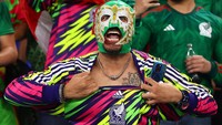 Seorang pendukung mengenakan topeng saat menyaksikan pertandingan Meksiko melawan Polandia di Stadion 974. (Chris Brunskill/Getty Images)  