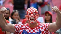 Pendukung Kroasia melukis wajahnya dengan bendera kebangsaan di Stadion Al-Bayt. (Ozan Kose/AFP/Getty Images)  