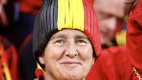 Seorang suporter Belgia memakai topi berwarna bendera kebangsaan yang berbentuk unik. (Mohammed Dabbous/Getty Images)  