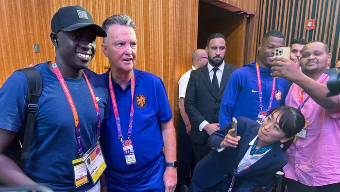 24 November 2022, Qatar, Doha: Louis van Gaal (2nd from left), national soccer coach of the Netherlands, stands next to journalist Papa Gueye from Senegal after a press conference. Van Gaal hugged Guye after the press conference after the latter told him how much he admires him instead of asking a question. (to dpa 
