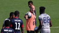 Wasit Antonio Mateu berbicara dengan pemain selama pertandingan latihan.