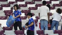Pendukung Jepang membersihkan tribun penonton pada akhir pertandingan sepak bola grup E Piala Dunia antara Jerman dan Jepang, di Khalifa International Stadium di Doha, Qatar, Rabu (23/11/2022). (AP Photo/Eugene Hoshiko).