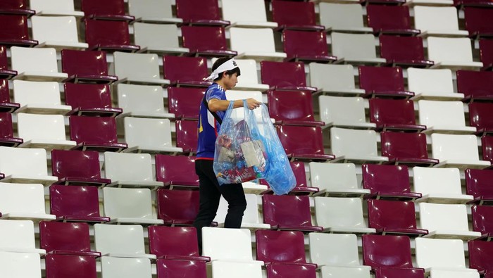 Salut! Suporter Jepang Punguti Sampah di Stadion Piala Dunia DOHA, QATAR - NOVEMBER 23: Japanese fans clear rubbish from the stands during the FIFA World Cup Qatar 2022 Group E match between Germany and Japan at Khalifa International Stadium on November 23, 2022 in Doha, Qatar. (Photo by Alex Grimm/Getty Images)