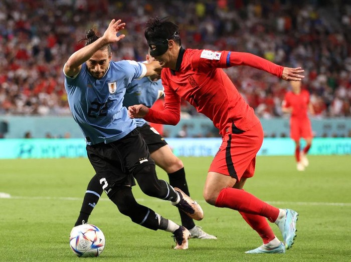 Sengit! Uruguay Vs Korea Selatan Berakhir Imbang Tanpa Gol AL RAYYAN, QATAR - NOVEMBER 24: Heungmin Son of Korea Republic battles for possession with Martin Caceres of Uruguay during the FIFA World Cup Qatar 2022 Group H match between Uruguay and Korea Republic at Education City Stadium on November 24, 2022 in Al Rayyan, Qatar. (Photo by Ryan Pierse/Getty Images)