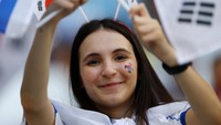 Dengan memegang bendera Korea Selatan, mereka menebar senyumannya di atas tribun Education City Stadium. Reuters/Kai Pfaffenbach 