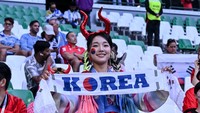Suporter wanita Korea Selatan membentangkan syal bertuliskan Korea saat memberikan dukungan kepada timnas kesayangan mereka yang bertanding melawan Uruguay pada laga grup H Piala Dunia 2022 di Education City Stadium di Al Rayyan, Qatar, Kamis (24/11/2022). Harry Langer/DeFodi Images/Getty Images 
